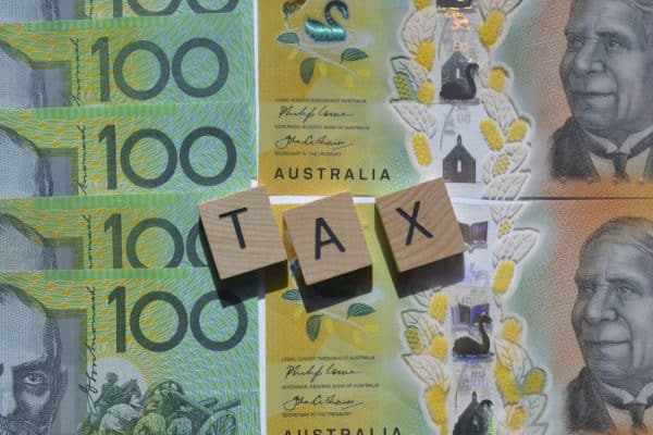 Money laid flat with the words TAX over it